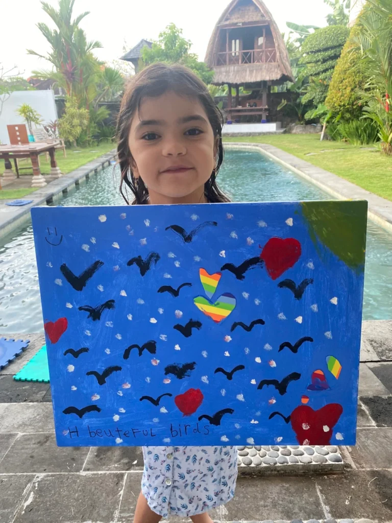 A girl showing her blue hand painting in the garden