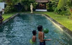 Two children playing with a ball in the pool