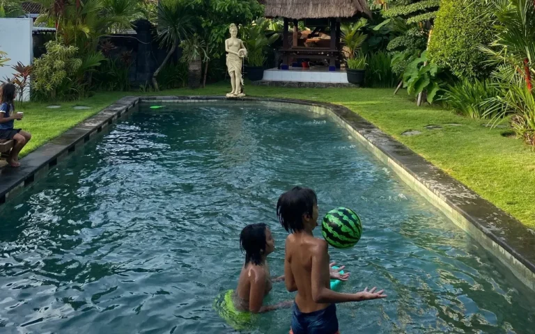 Two children playing with a ball in the pool